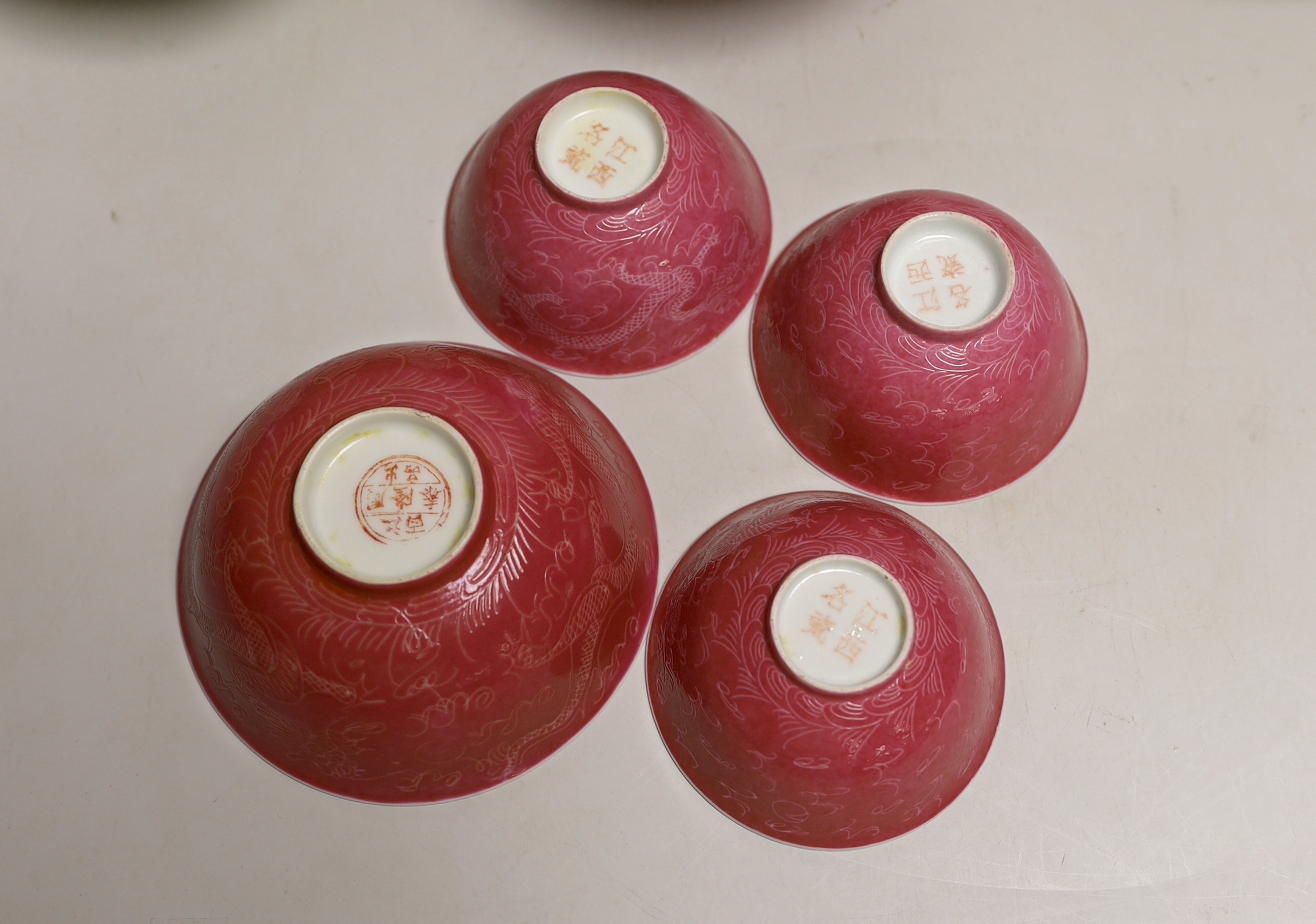 Five Chinese pink monochrome bowls decorated with dragons chasing the flaming pearl together with a yellow ground pair, largest 16cm in diameter